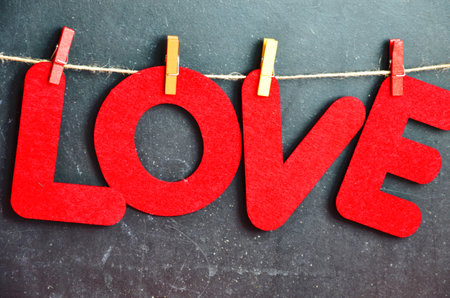 red letters hang on clothespins Valentine day and christmas background. Blurred word Love for...
