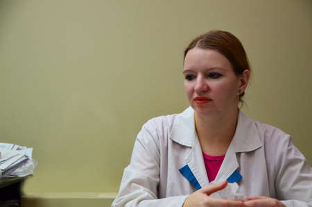 Portrait of female doctor in special surgical sterile protective clothing. puts on a mask and gloves before receiving a patient in the officeの写真素材