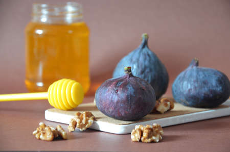 ripe figs with honey and walnuts on a brown background, ingredients for a healthy breakfast, no sugar, diet. Healthy breakfast of superfoods, quinoa, honey, nuts, figs, coffee. Top viewの写真素材