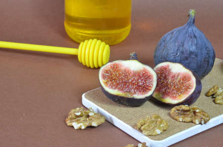 ripe figs with honey and walnuts on a brown background, ingredients for a healthy breakfast, no sugar, diet. Healthy breakfast of superfoods, quinoa, honey, nuts, figs, coffee. Top viewの写真素材