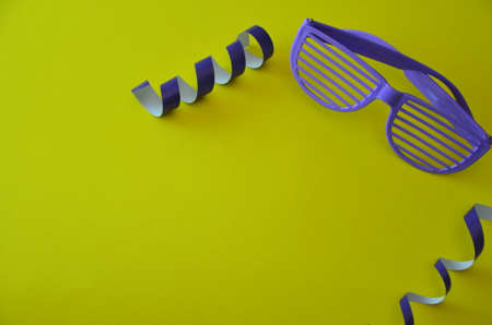glasses with purple stripes on a yellow background with a serpentine. attributes of a party,...