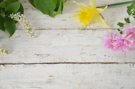 spring white and lilac or purple flowers on wooden white background and yellow daffodils. background for spring holidays. mothers day, easterの写真素材