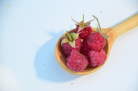 Spoon with ripe aromatic raspberries on table, top viewの写真素材