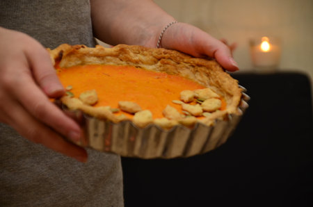 girl holding in her arms. Fresh Homemade Pumpkin Pie made for Thanksgiving. celebrating a holiday in autumn or winter. homemade bakingの写真素材