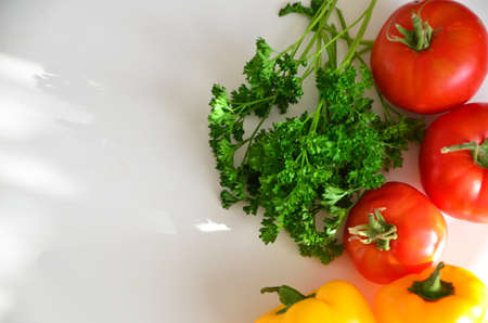 fresh organic vegetables and greens, tomatoes, sweet yellow peppers, diet and proper nutrition concept. Vegetables top view on white isolated backgroundの写真素材