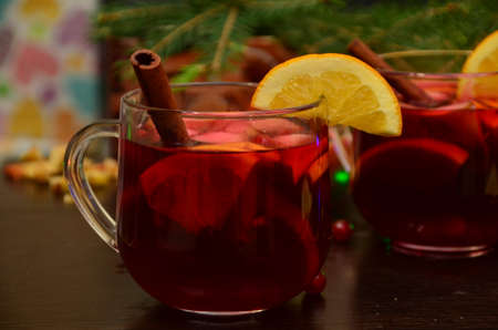 Christmas mulled red wine with spices and fruits on a wooden rustic table. Traditional hot drink at Christmas timeの写真素材