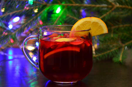 Christmas mulled red wine with spices and fruits on a wooden rustic table. Traditional hot drink at Christmas timeの写真素材