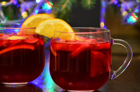 Christmas mulled red wine with spices and fruits on a wooden rustic table. Traditional hot drink at Christmas timeの写真素材