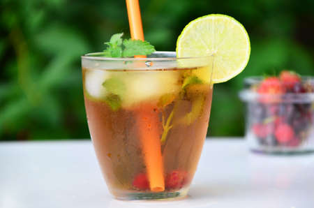summer drink, tea with wild berries, lime, raspberries and blueberries, summer vacation, vacations. Raspberry mojito cocktail with lime, mint and ice, cold, iced refreshing drink or beverage.の写真素材