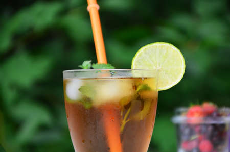 summer drink, tea with wild berries, lime, raspberries and blueberries, summer vacation, vacations. Raspberry mojito cocktail with lime, mint and ice, cold, iced refreshing drink or beverage.の写真素材