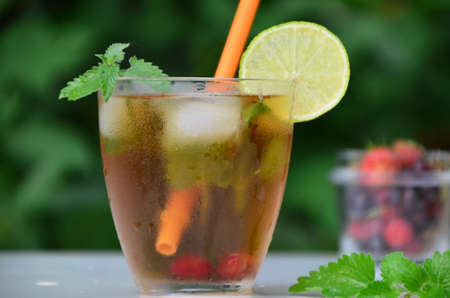 summer drink, tea with wild berries, lime, raspberries and blueberries, summer vacation, vacations. Raspberry mojito cocktail with lime, mint and ice, cold, iced refreshing drink or beverage.の写真素材