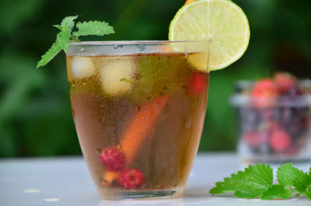 summer drink, tea with wild berries, lime, raspberries and blueberries, summer vacation, vacations. Raspberry mojito cocktail with lime, mint and ice, cold, iced refreshing drink or beverage.の写真素材