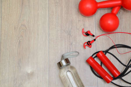 still life of group sports equipment for womens and cardiogram of jump rope. Fitness and healthy living, wellness concept. sneakers, water, sweat, headphones.の写真素材