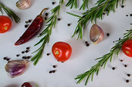 Food and drink healthy lifestyle concept: Italian herbs and spices. Rosemary, tomatoes, garlic and peppers. top view. isolated on white. Tomatoes and various herbs spices isolated on white background.の写真素材