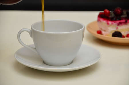 Fruit dessert and coffee low-calorie dessert with berries and cream. pour coffee and cream into a cup.の写真素材