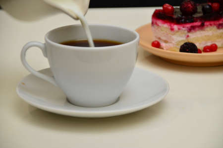 Fruit dessert and coffee low-calorie dessert with berries and cream. pour coffee and cream into a cup.の写真素材