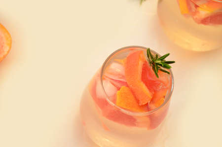Refreshing grapefruit cocktail with ice and rosemary on a white background. rosemary on the table. or detox water or smoothie. low calorie diet.の写真素材