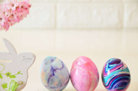 Colorful easter quail eggs in nest and tulips on pink background with . flat lay. spring composition. Happy easter greeting card. copy spaceの写真素材