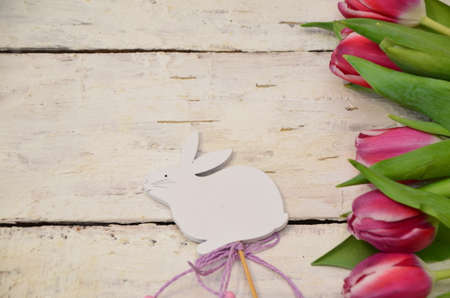 Colorful easter quail eggs and tulips on white wooden background with . flat lay. spring composition. Happy easter greeting card. copyspace.の写真素材