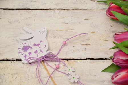 Colorful easter quail eggs and tulips on white wooden background with . flat lay. spring composition. Happy easter greeting card. copyspace.の写真素材