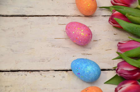 Colorful easter quail eggs and tulips on white wooden background with . flat lay. spring composition. Happy easter greeting card. copyspace.の写真素材