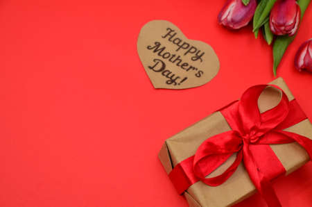 mother's day, woman's day. tulips ,presents on wooden white background, greeting card with the inscription happy mother's day, heartsの写真素材