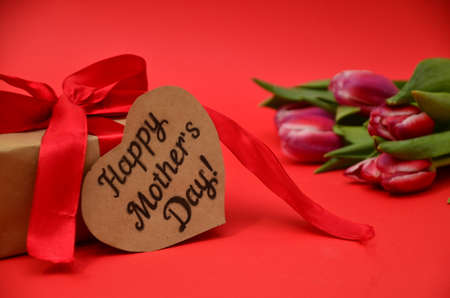 mother's day, woman's day. tulips ,presents on wooden white background, greeting card with the inscription happy mother's day, heartsの写真素材