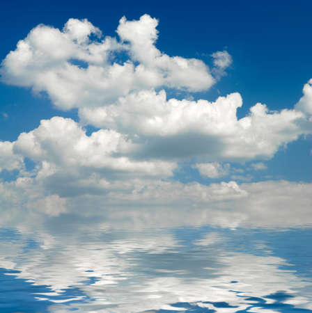 White clouds and blue sky mirrored in waterの写真素材