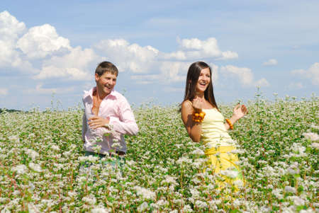 Young couple on field of flowers in sunny day の写真素材
