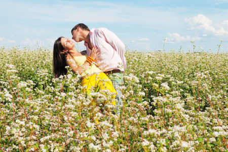 Young couple on field of flowers in sunny dayの写真素材