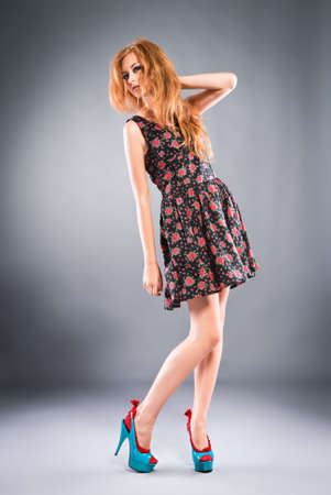 Beautiful red-haired girl on grey background/ Studio shotの写真素材