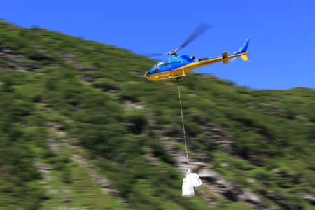 movement of goods in the mountains by helicopter on the background with  motion blur の写真素材