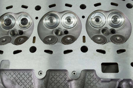 Intake and exhaust valves installed in the head of the block of a gasoline three cylinder internal...