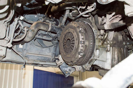 Bottom view of the engine compartment of the car, which is located in an auto repair shop with the...