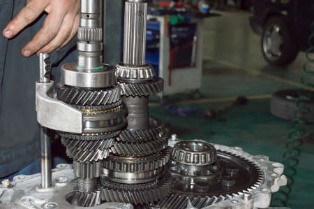 Side view of shafts and gears of a partially disassembled mechanical transmission in an auto repair...