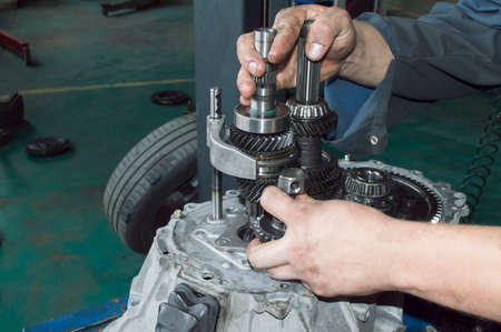 The mechanic sets the intermediate gear of the rear gear of the mechanical transmission with his...