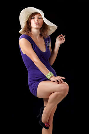 girl in sexy dress with a hat isolated on black backgroundの写真素材