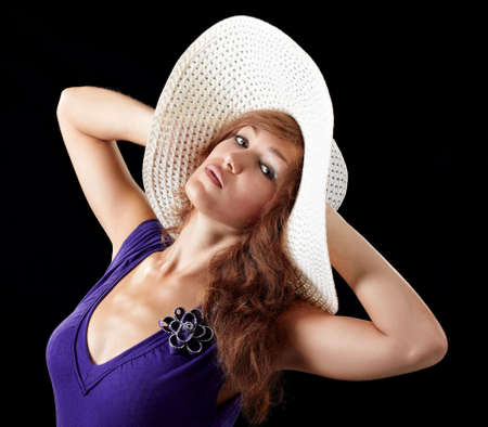 girl in sexy dress with a hat isolated on black backgroundの写真素材