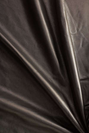 natural shiny black folded leather vertical backgroundの写真素材