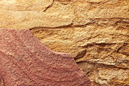 Combination of red and yellow stone texture closeup backgroundの写真素材