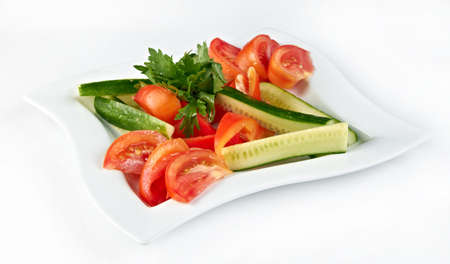 plate of fresh cut cucumbers and tomatoesの写真素材