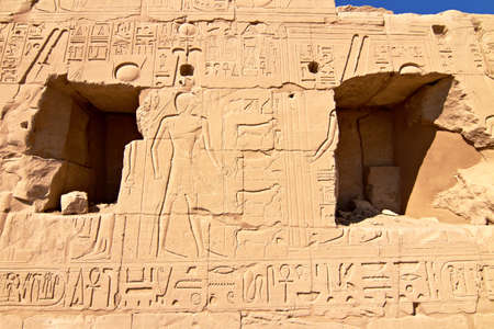 Part of a wall with hieroglyphs and shadow as background