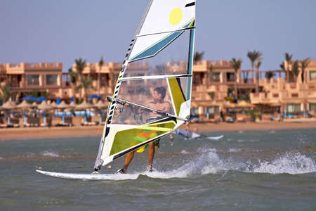 Young man windsurfing with trailing wakeの写真素材