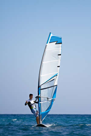 Front view of young man having fun at windsurfingの写真素材