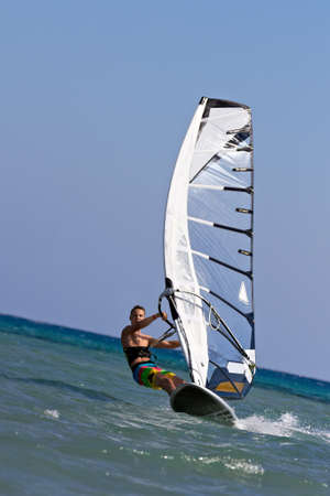 Young man surfing the wind on a bright summer dayの写真素材