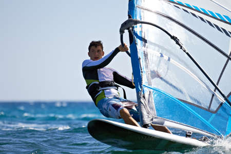Front view of young windsurfer passing by close-upの写真素材