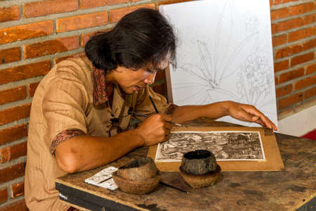 Young painter drawing in gallery, Bali, Indonesiaの写真素材
