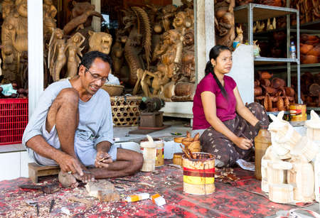 A man and a woman are making wooden crafts in Indonesiaのeditorial素材