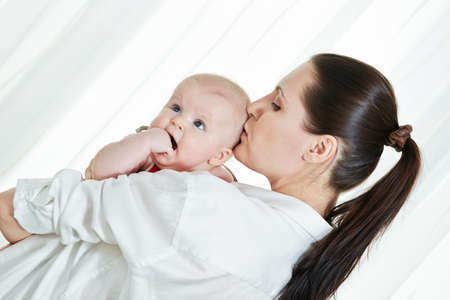 Mother with her child on arms on white backgroundの写真素材