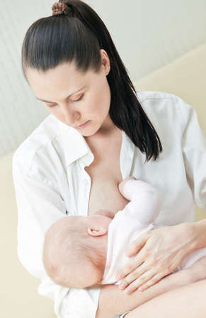 Mother nurse her child on a sofaの写真素材